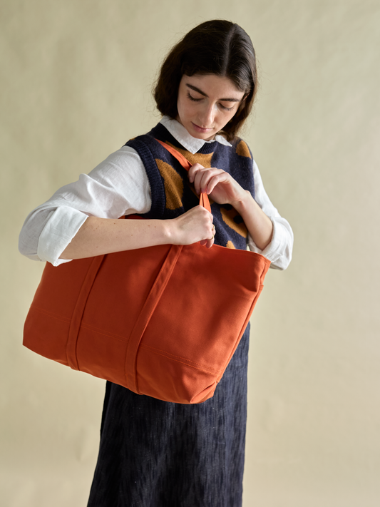 domecíl Orange Canvas Tote being carried on the shoulder of model in front of light background