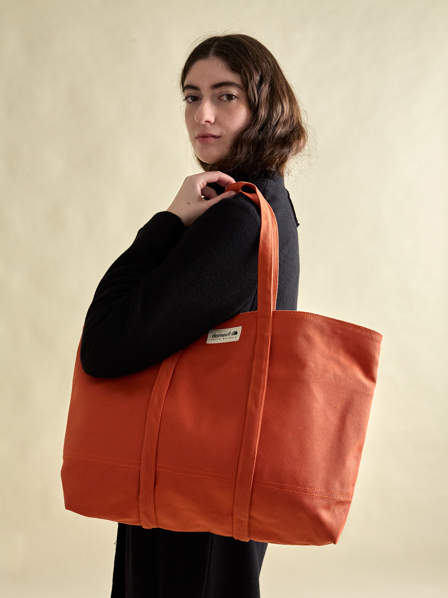 Model looking over shoulder with domecíl Orange Canvas Tote