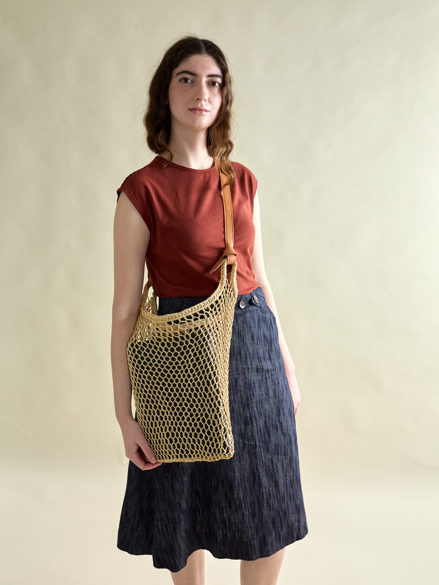 Maguey Tote with leather tie straps pictured on model with navy skirt and maroon top