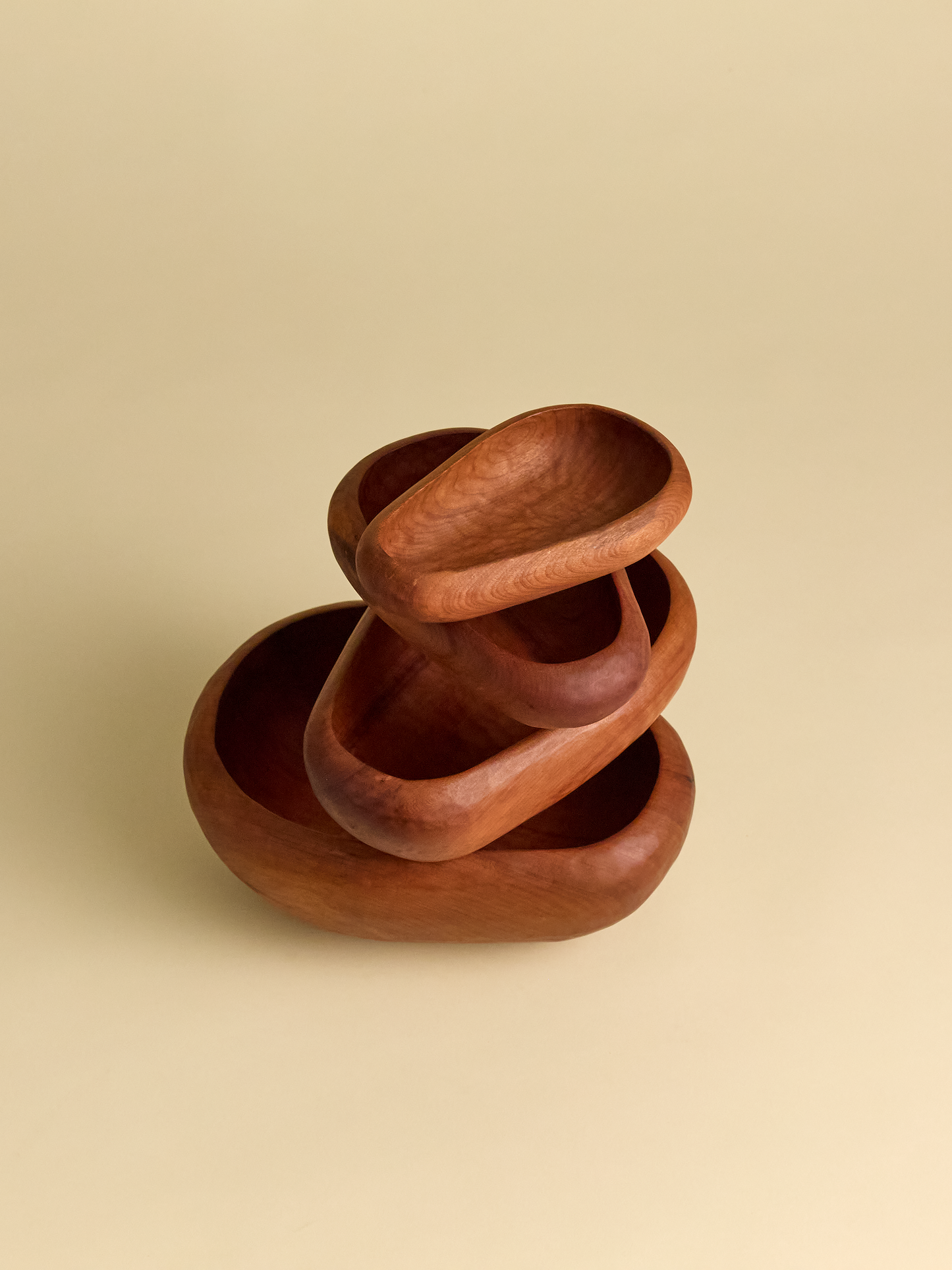 Hand Carved Rauli Nesting Bowls stacked in various directions on light background