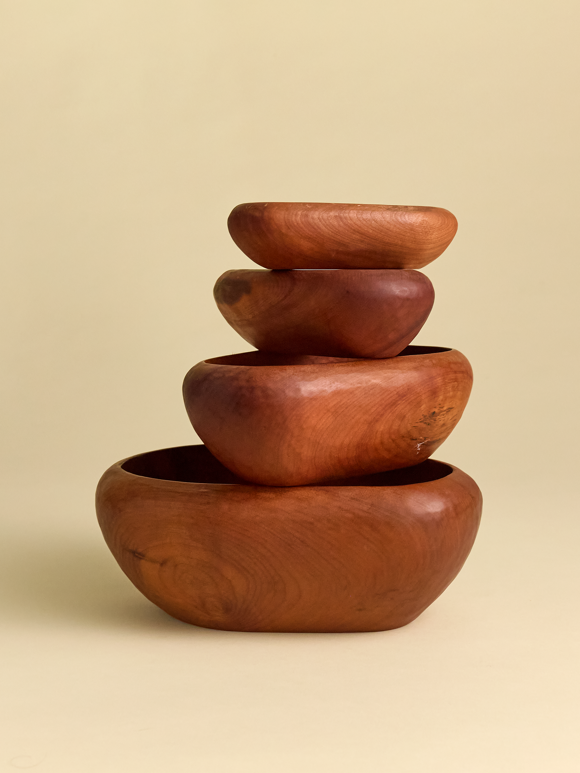 Hand Carved Rauli Nesting Bowls stacked on top of one another on light background