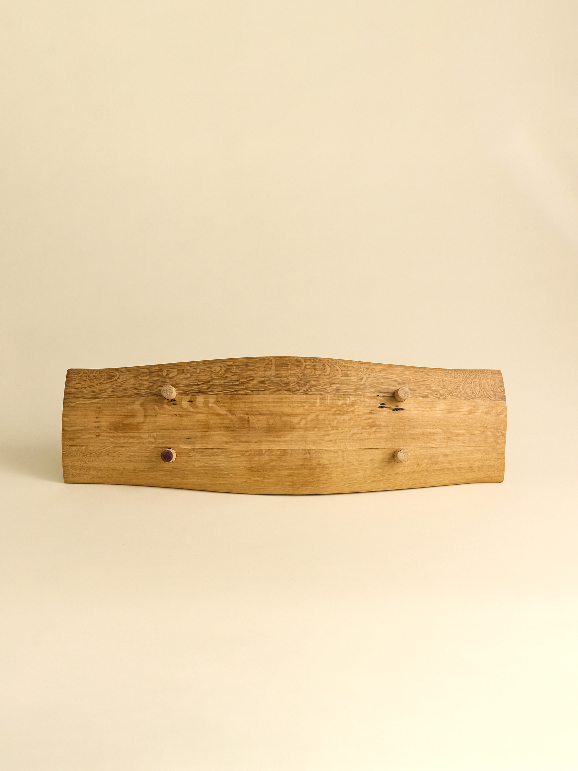 French Oak Barrel Platter tipped on it's side showing the underneath of the platter with cork feet