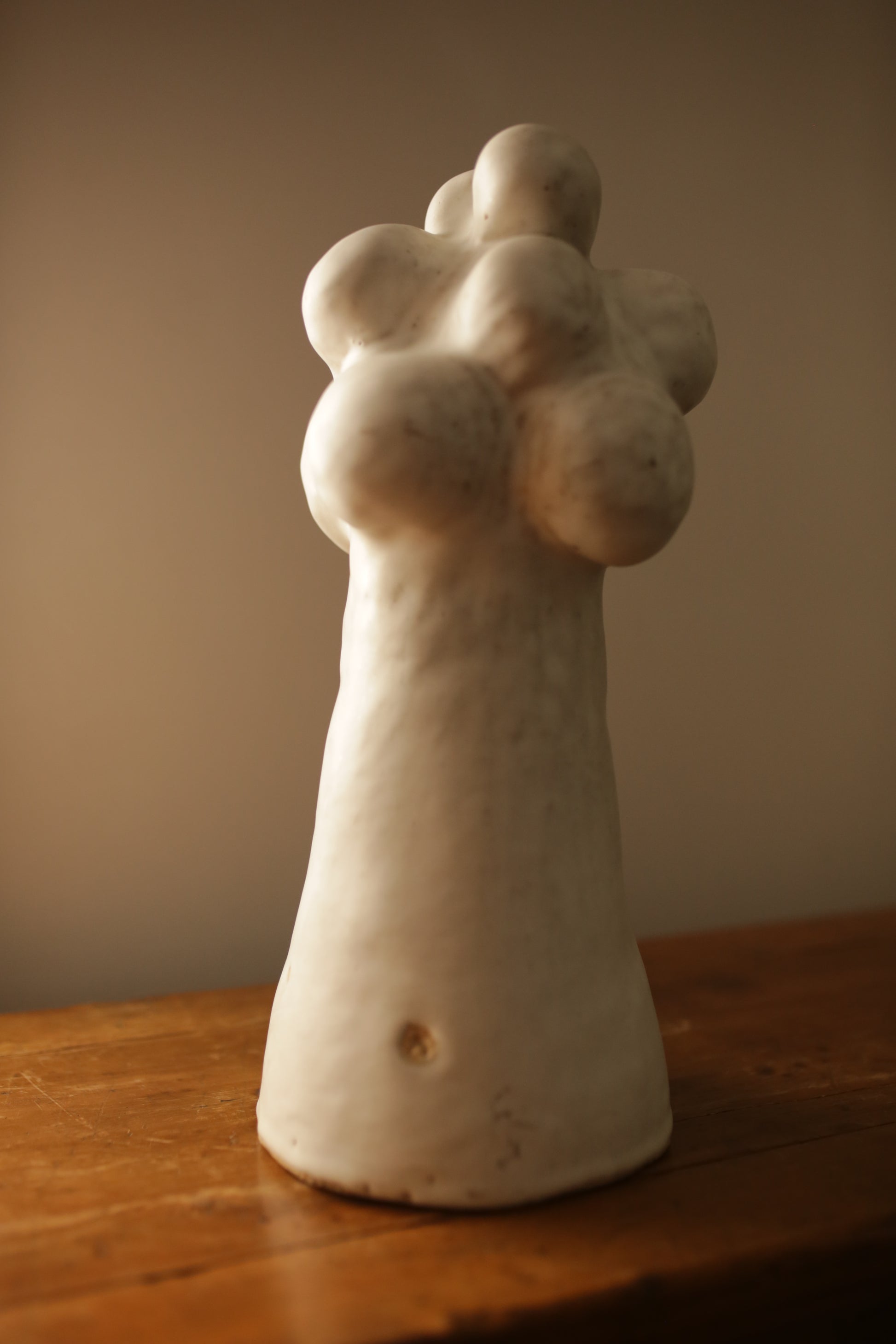 Pascale Vaqutte ceramic matte glaze Cloud  Sculpture against a wooden and beige background