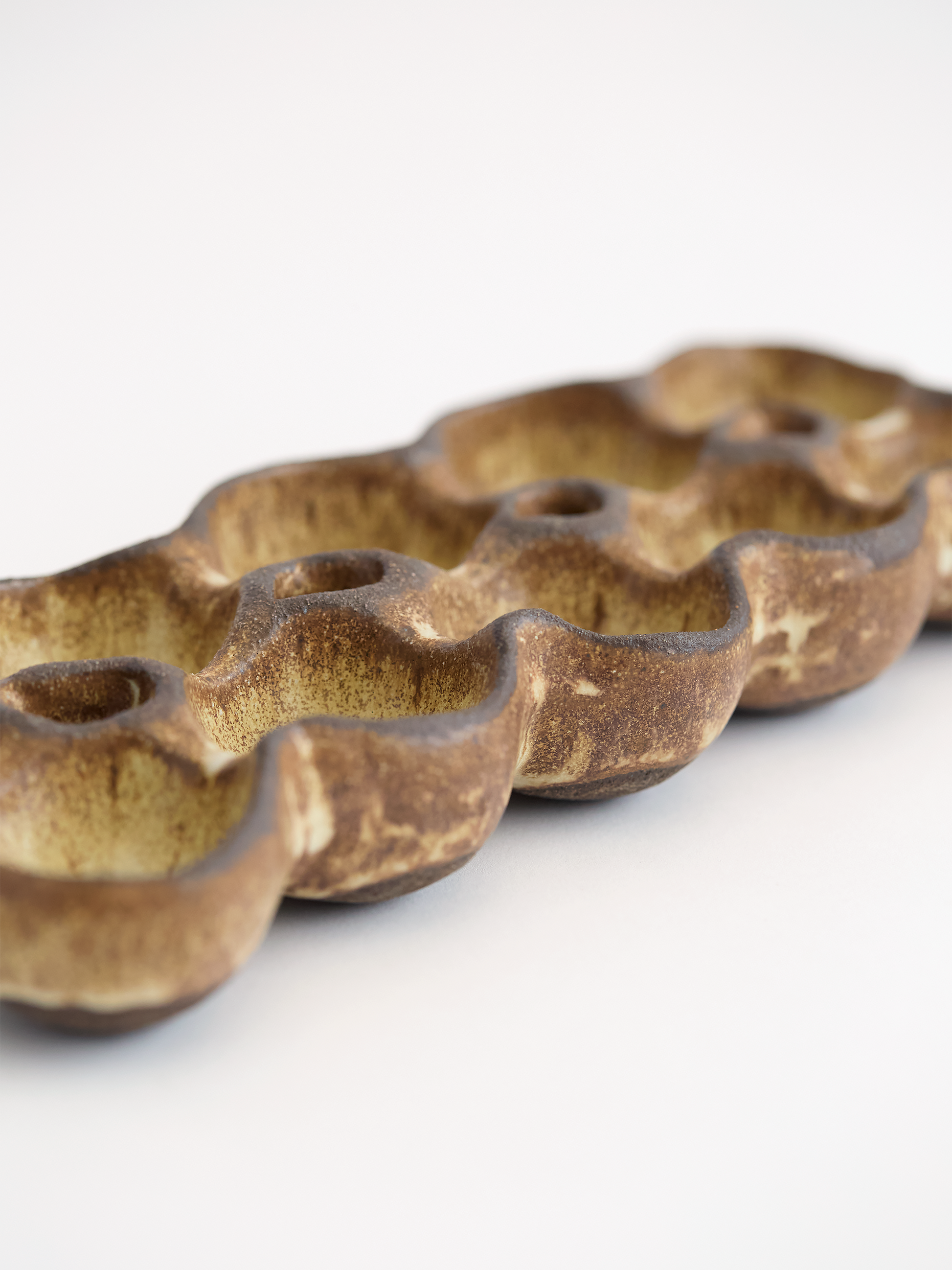 Olive brown ceramic egg holder on a white background