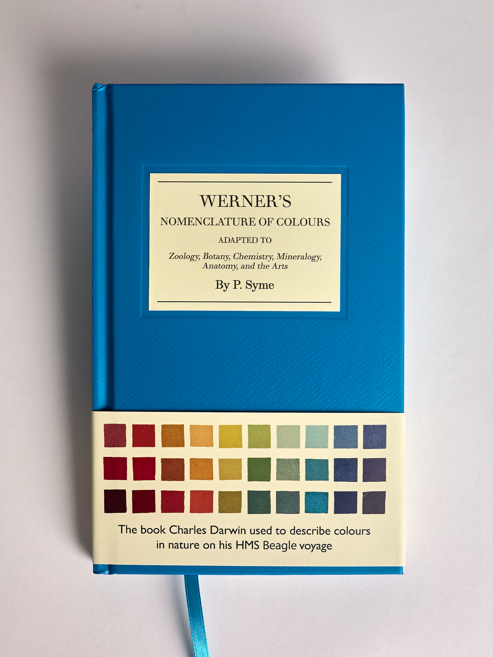 Blue book titled 'Werner's Nomenclature of Colours' with color swatches on a gray background