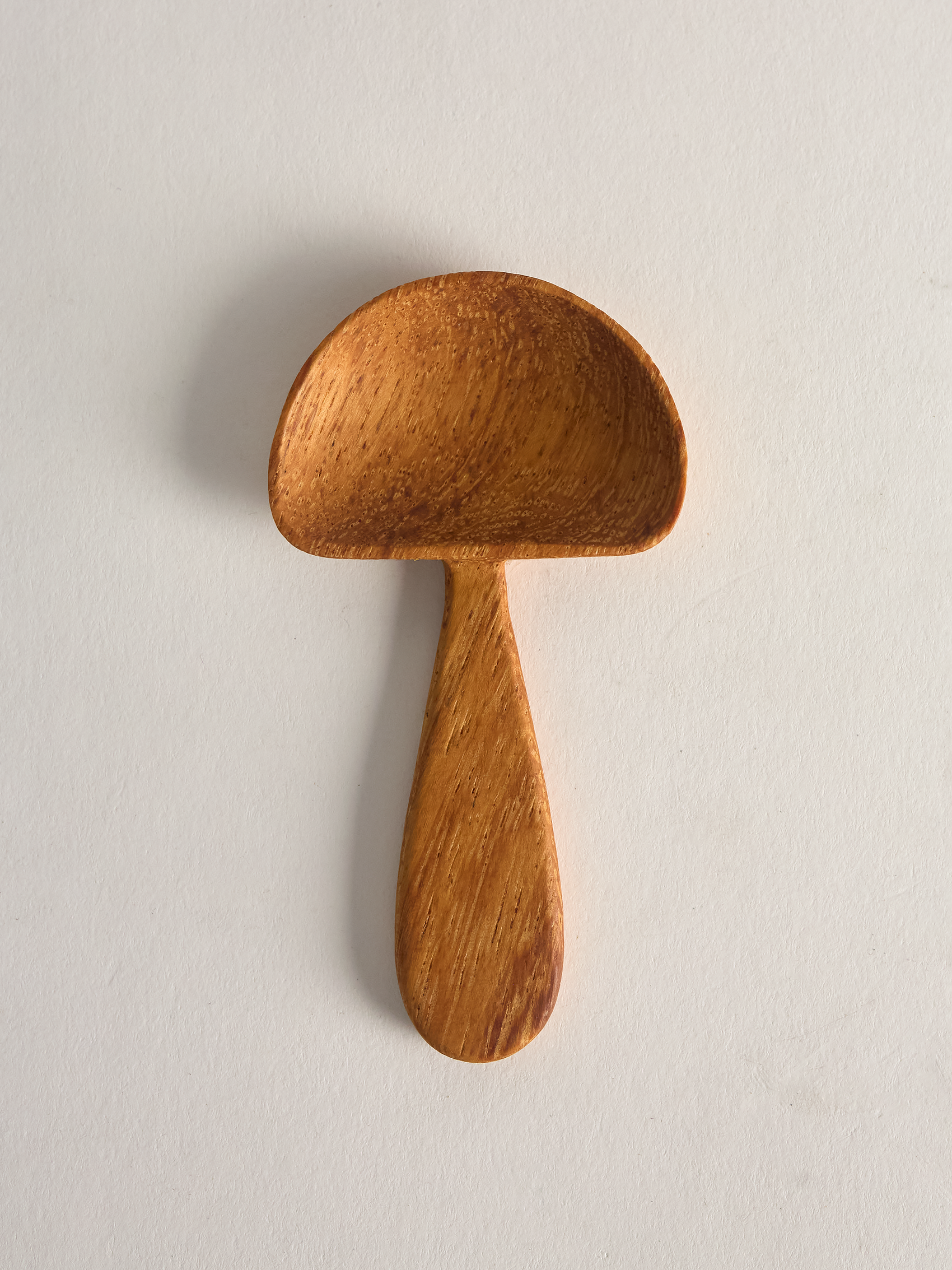 small Wooden mushroom shaped spoon on a light gray background