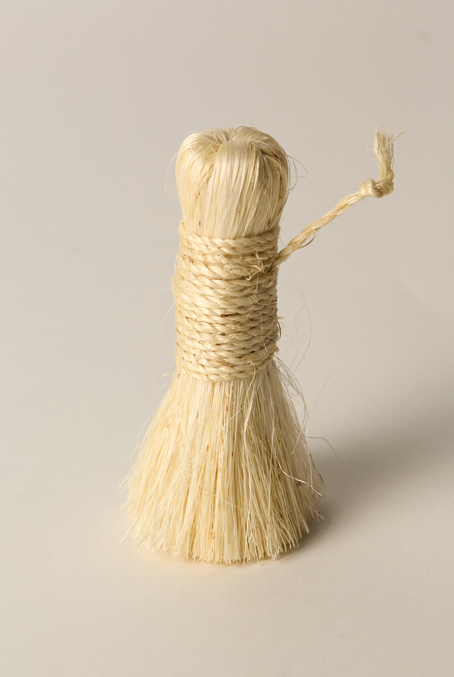 Handmade brush made from Tampico fiber plain background
