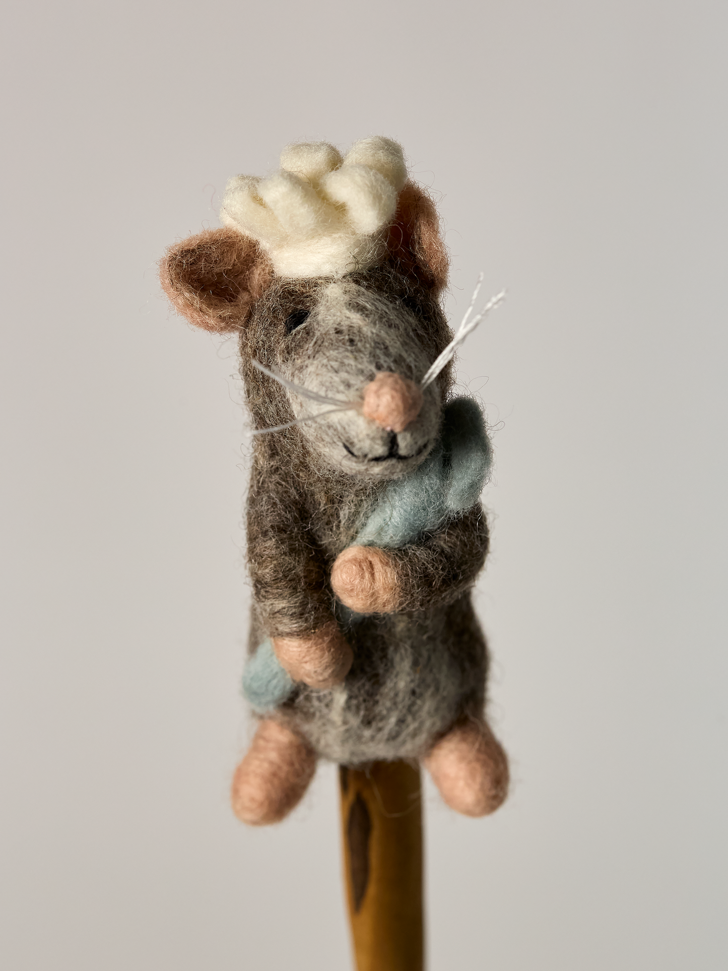 Felted finger puppet Chef mouse toy with a blue chef spoon on a gray background