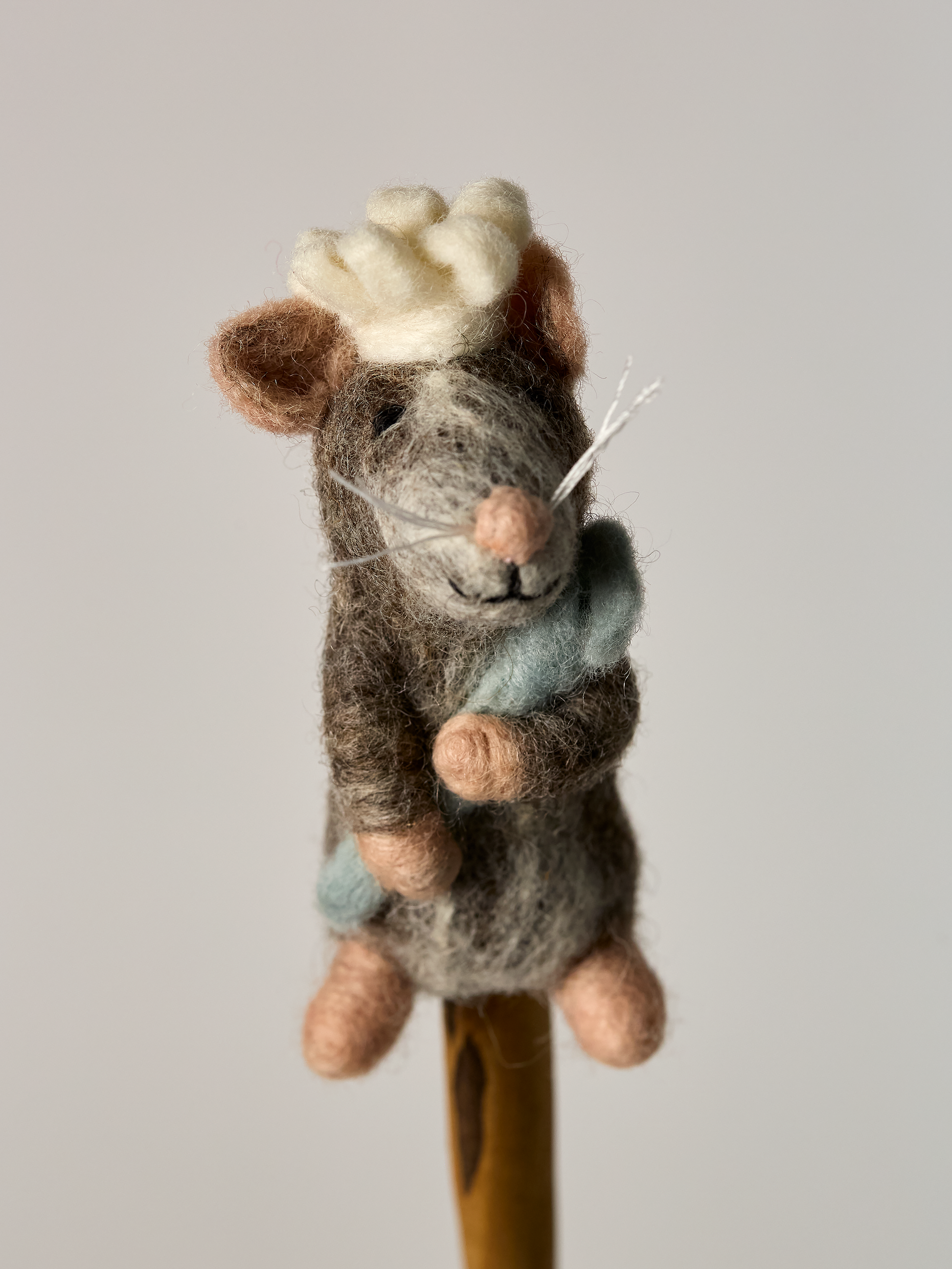 Felted finger puppet Chef mouse toy with a blue chef spoon on a gray background
