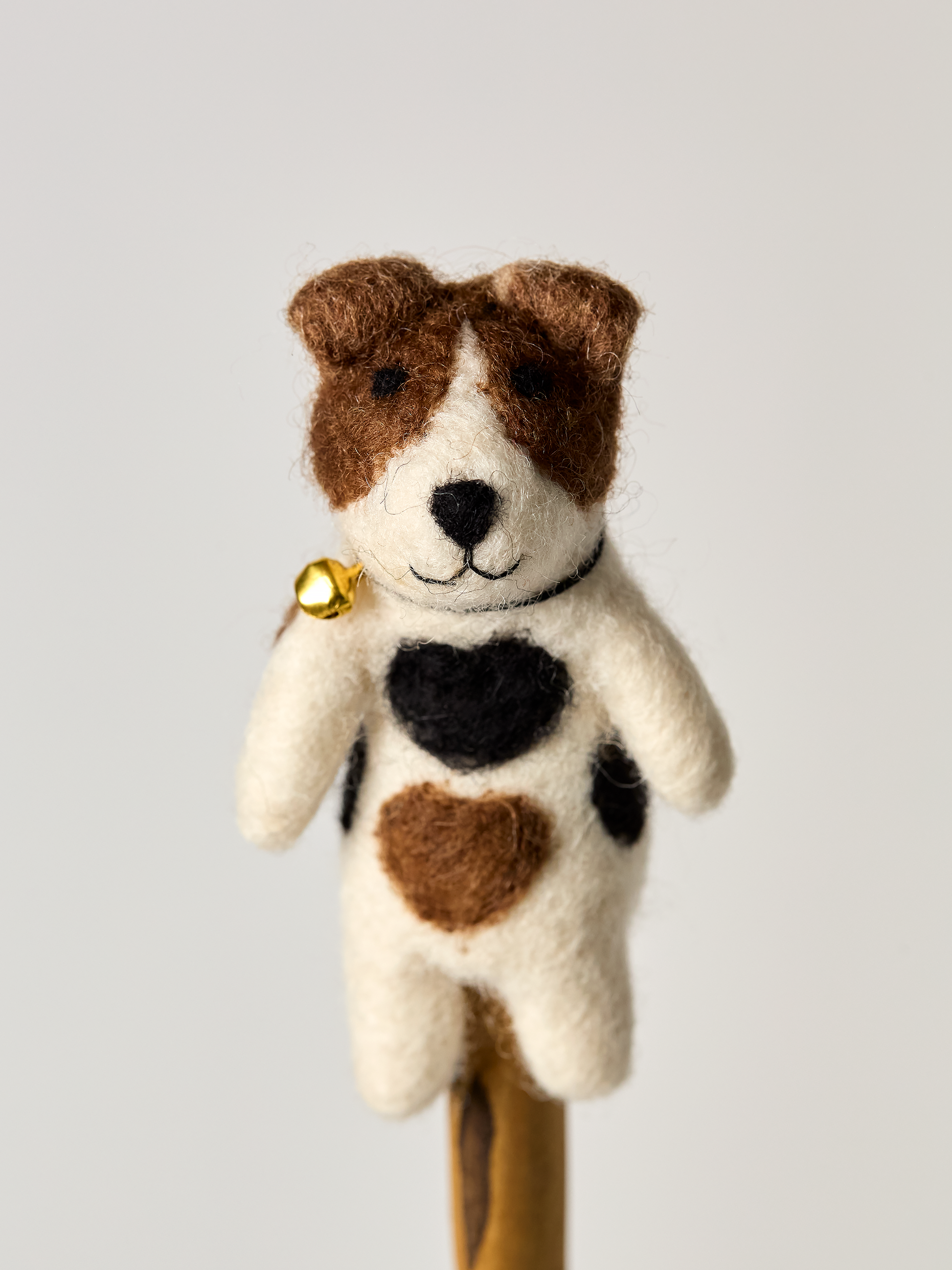 Jack Russel finger puppet dog toy with a heart pattern and a bell on a white background
