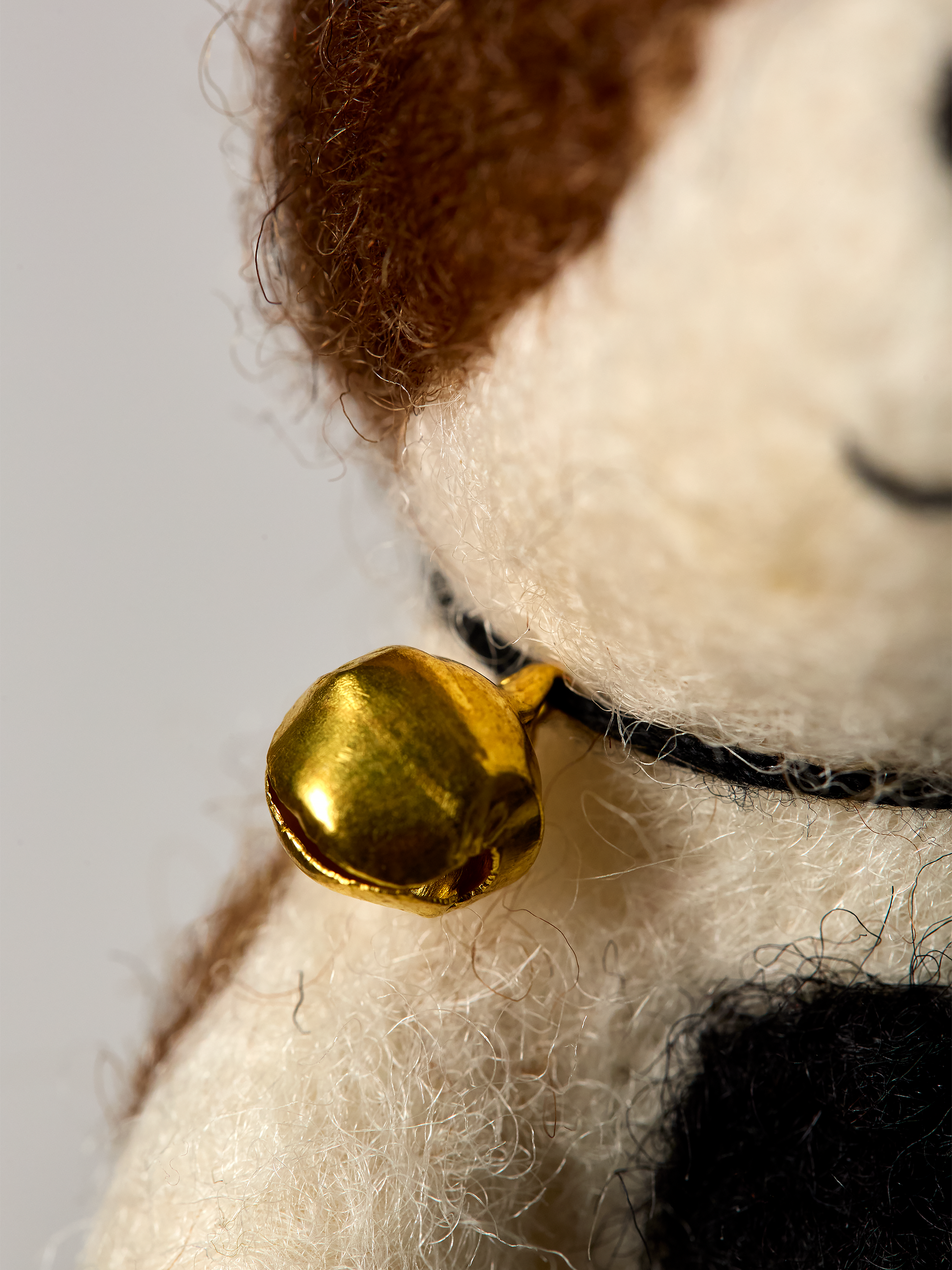 Close-up of Jack Russel finger puppet dog toy a bell on a white background