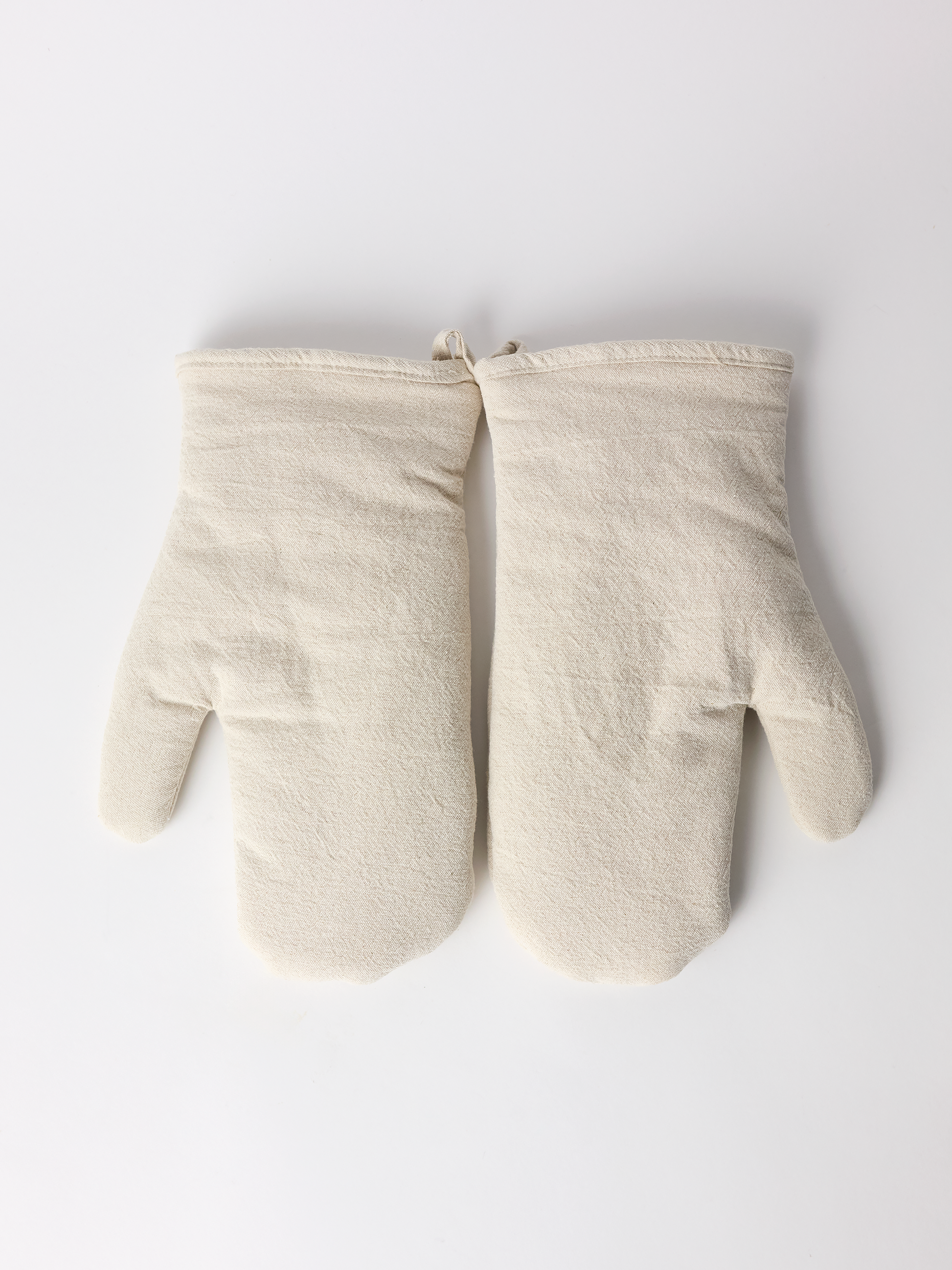 Pair of beige oven mitts on a white background