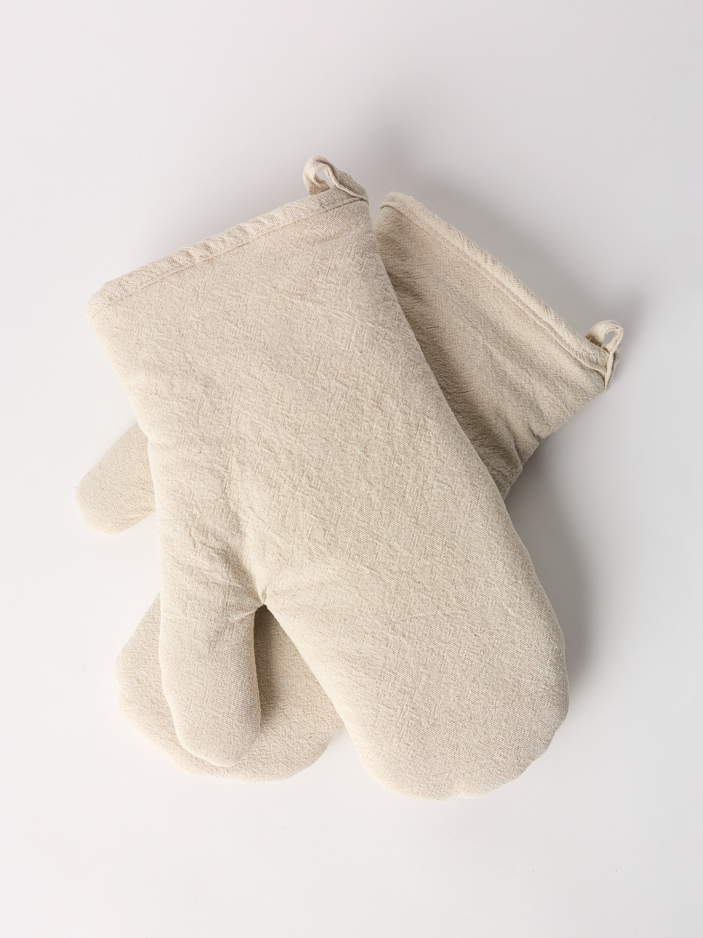 Beige oven mitt and pot holder on a light gray background