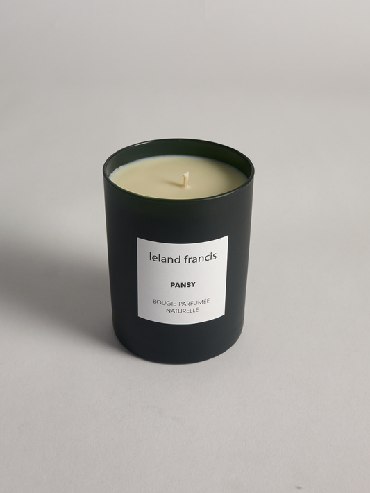 Pansy Candle from Leland Francis  in a dark green container with a white label on a light gray background
