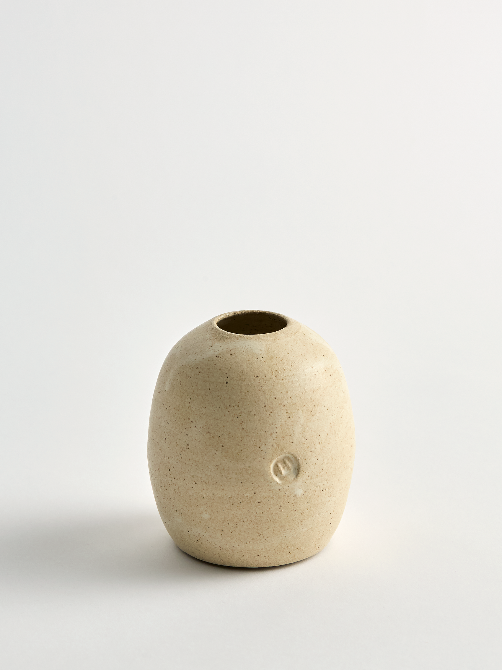  beige surface  Lorie Stout  ceramic bud vase with on a light gray background