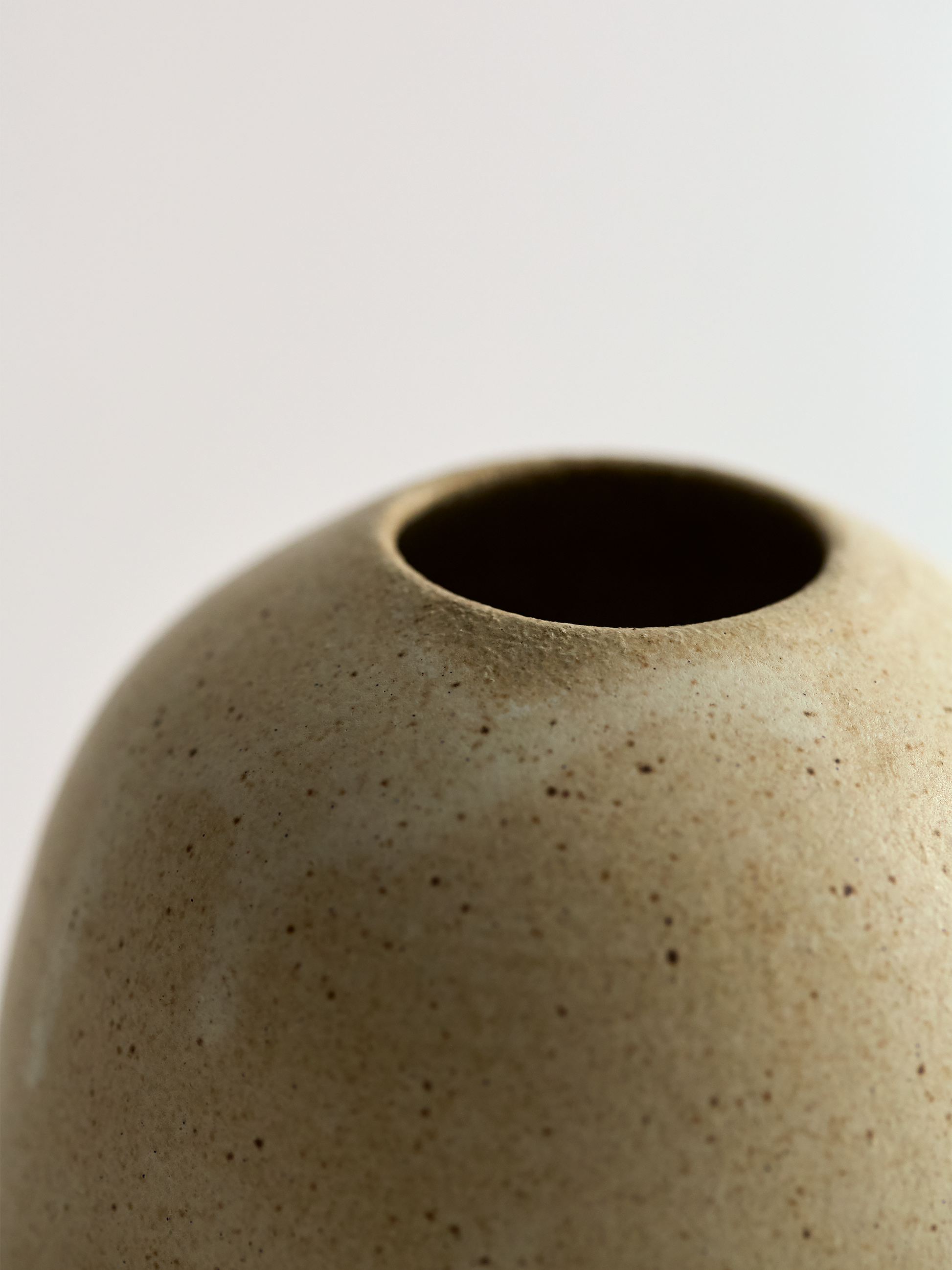 Close-up of a textured ceramic vase on a light gray background