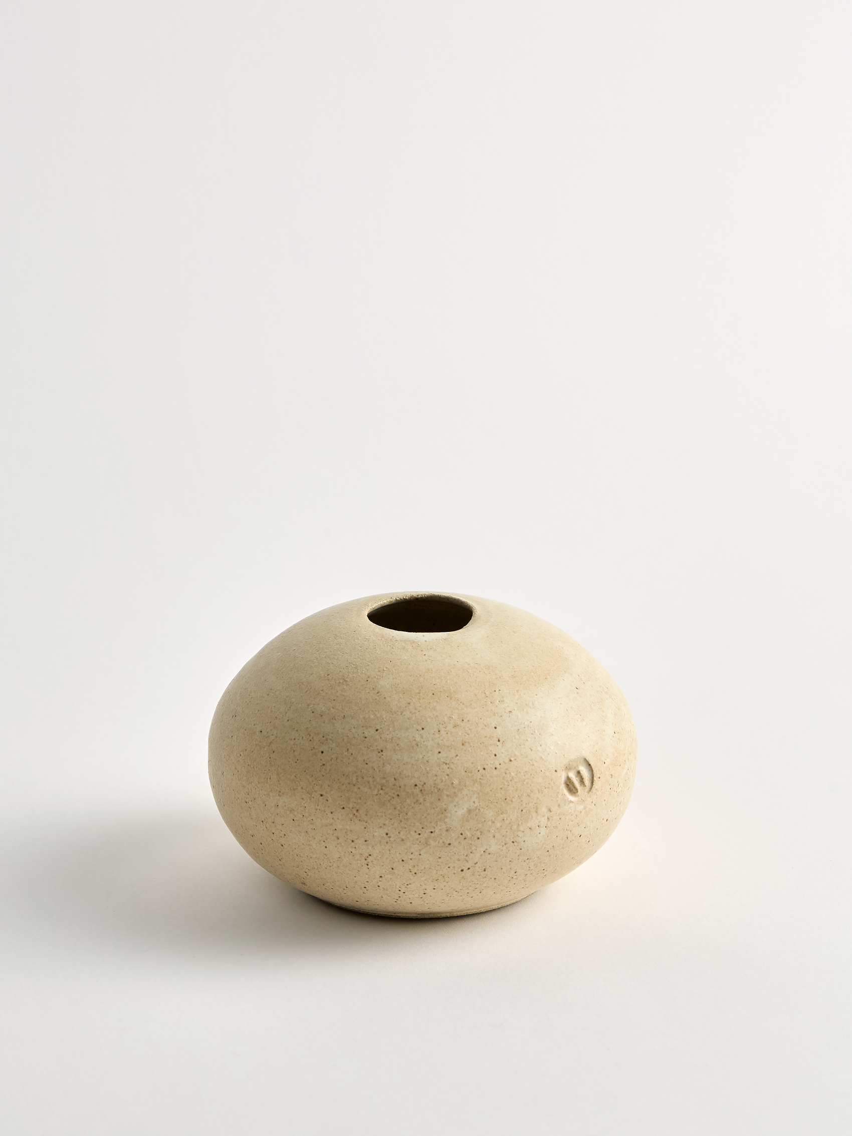 Lorie Stout Small beige ceramic bud vase with mark on a light gray background