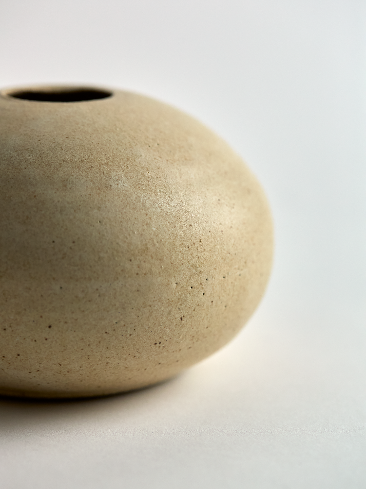 Beige ceramic vase on a light gray background