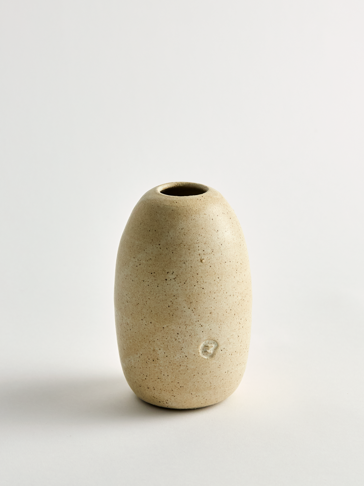 Lorie Stout Pottery beige ceramic vase showing press mark on a light gray background