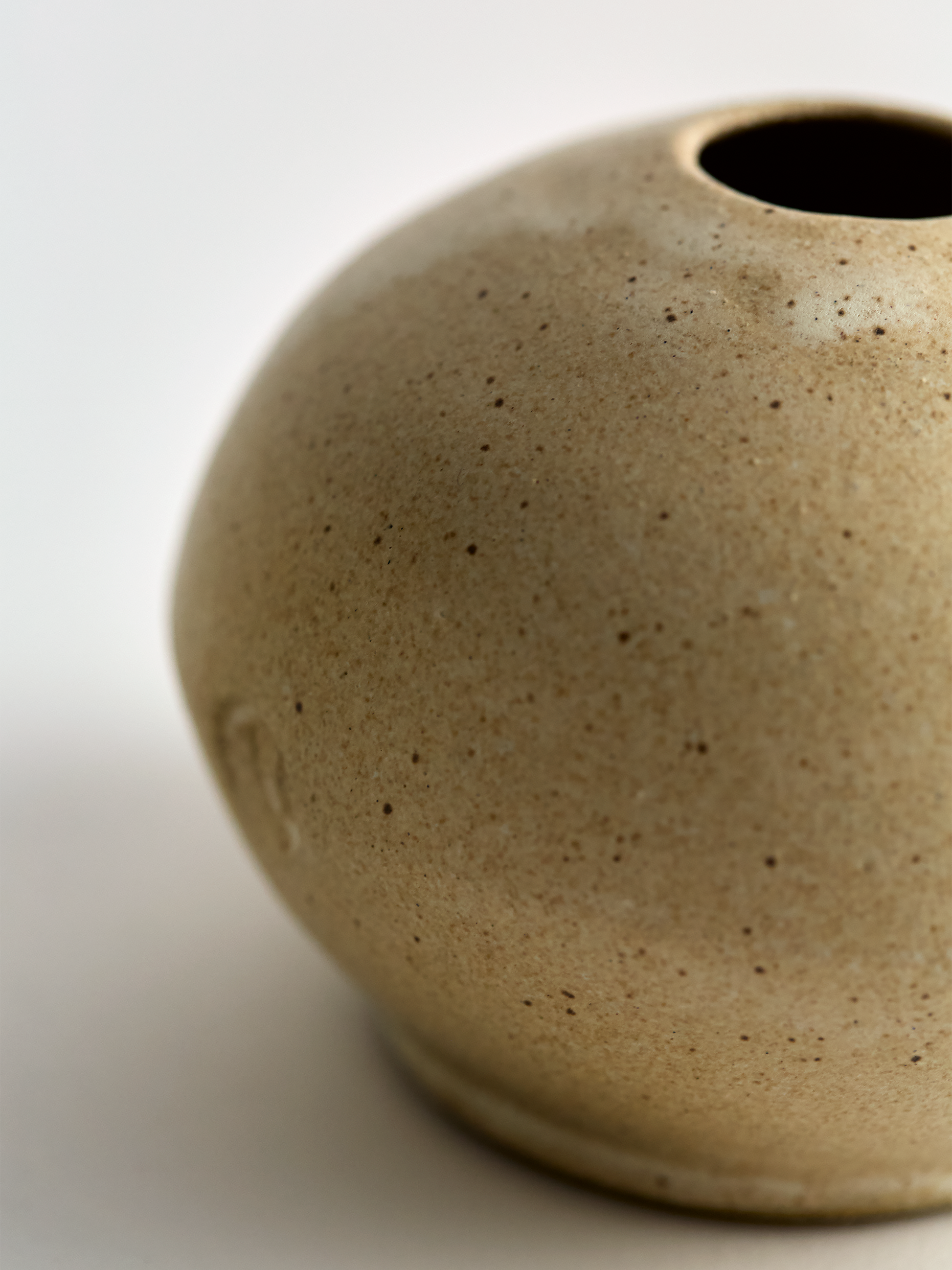 Close-up of a Lorie Stout textured ceramic vase on a light background