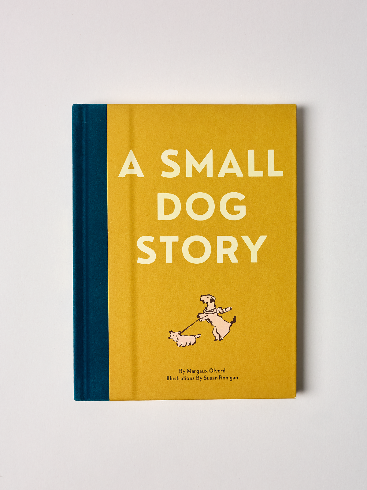Book titled 'A Small Dog Story' with a yellow cover and blue spine on a light gray background