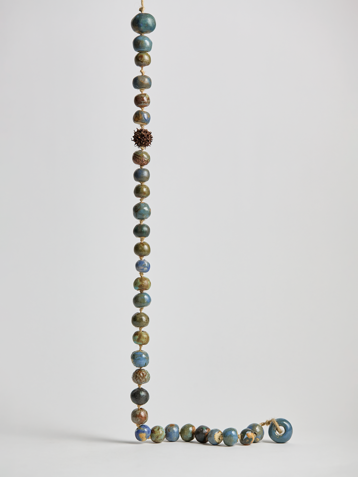 Ceramic Garland, hand crafted Blue glazed  beads on a rope with light background