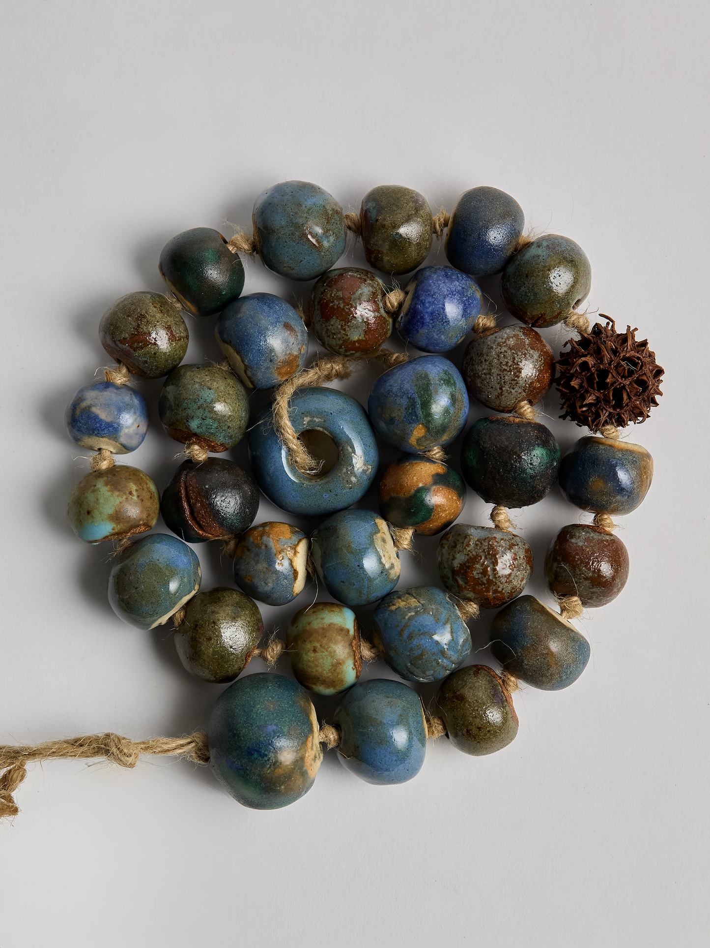 Ceramic Garland, hand crafted Blue glazed  beads in a coiled pattern with light background