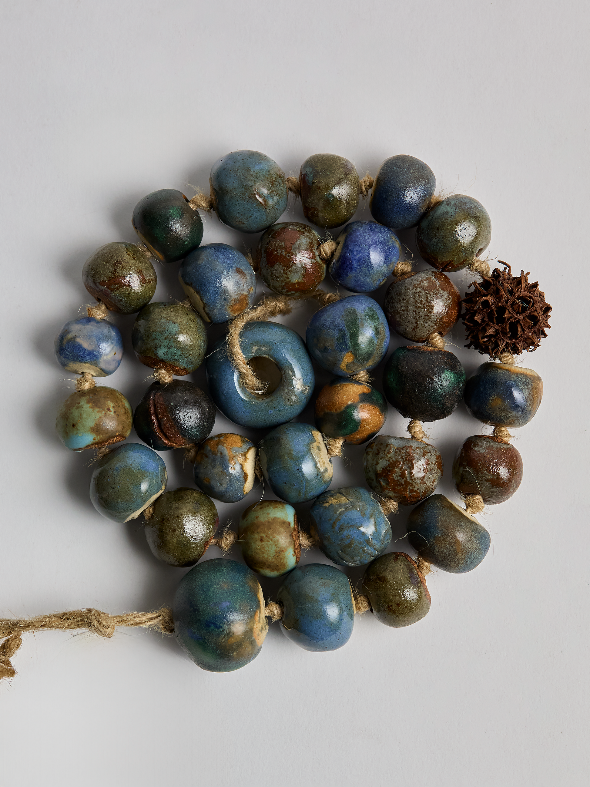 Ceramic Garland, hand crafted Blue glazed  beads in a coiled pattern with light background