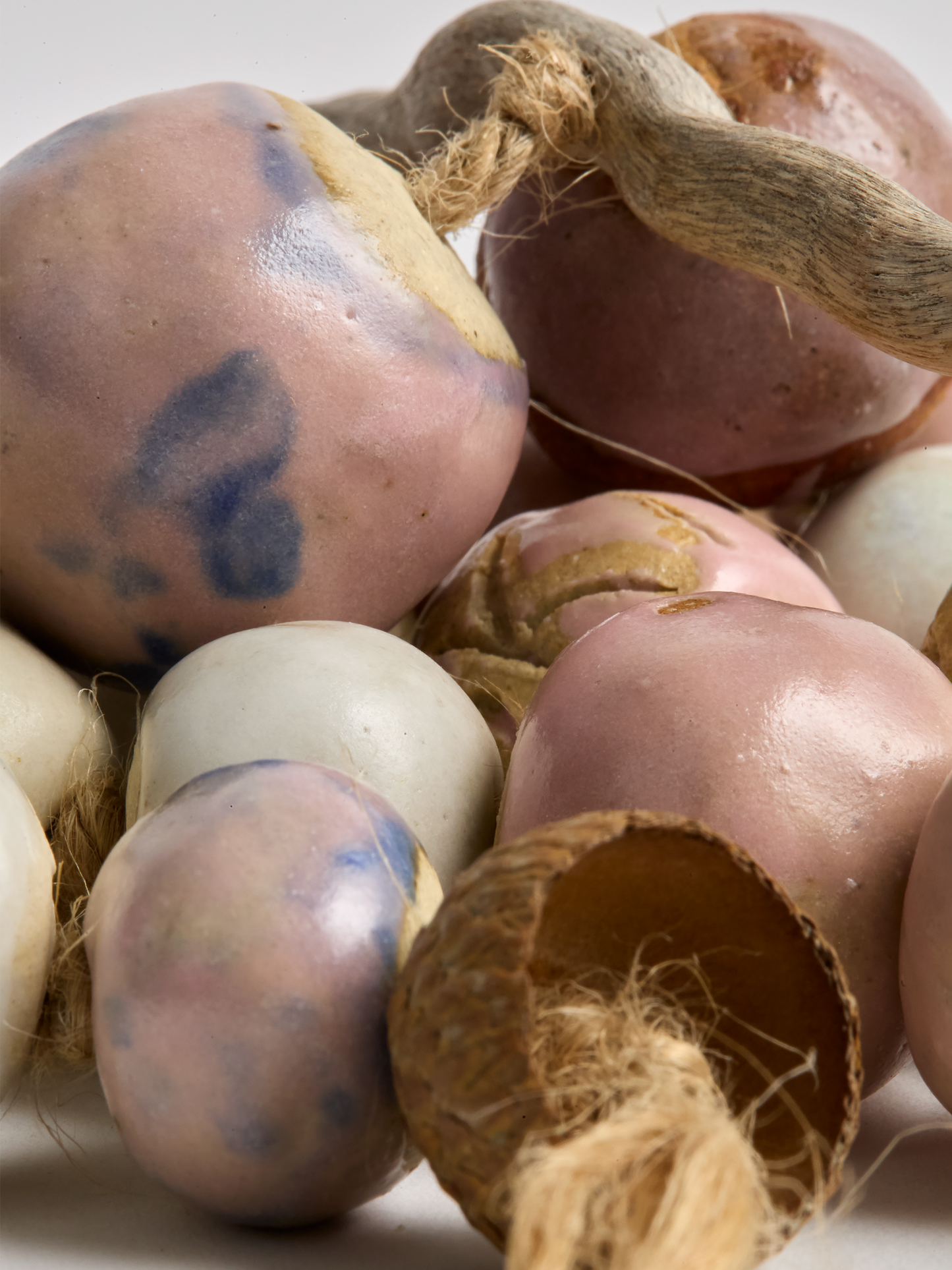 Close-up Pink & Cream Ceramic Garland handcrafted beads on a rope with twig and acorn
