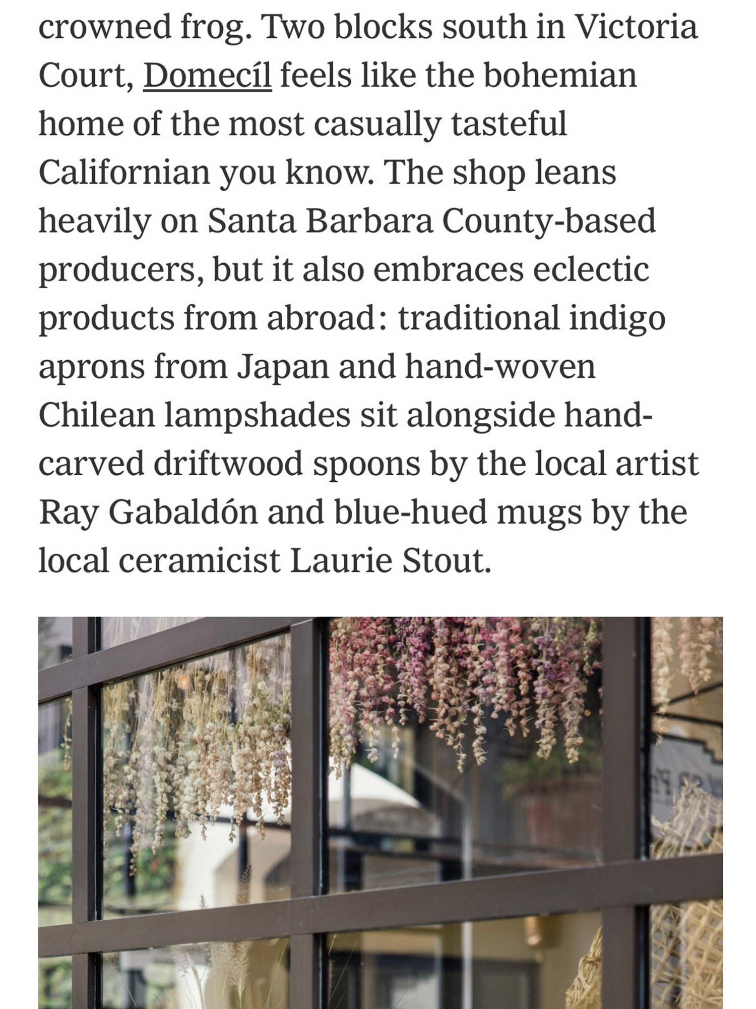 Text describing  domecil in Victoria Court with decorative elements like indigo aprons, Chilean lampshades, driftwood spoons, and blue-hued mugs.