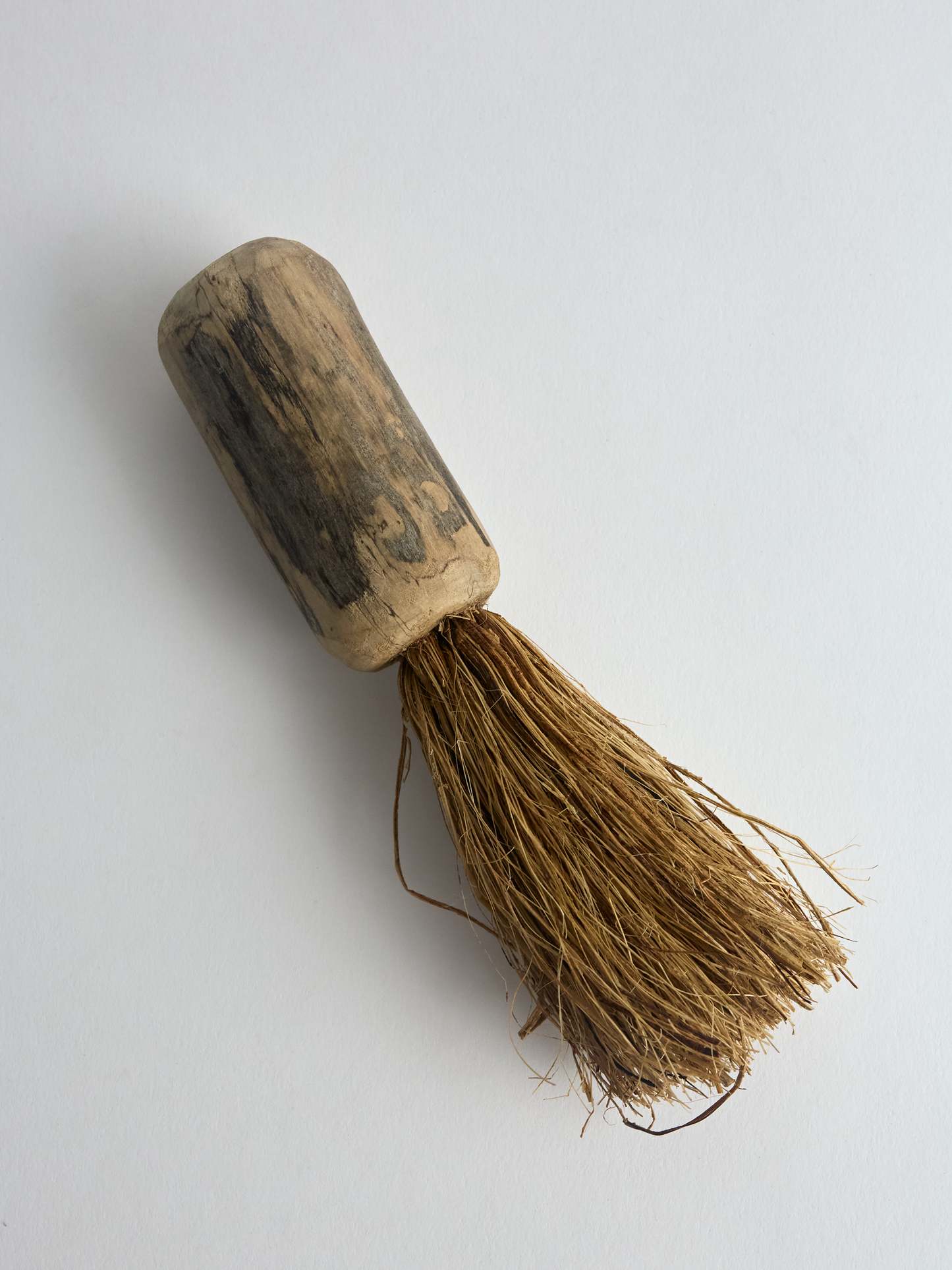 Traditional hemp brush with sanded driftwood handle on a white background
