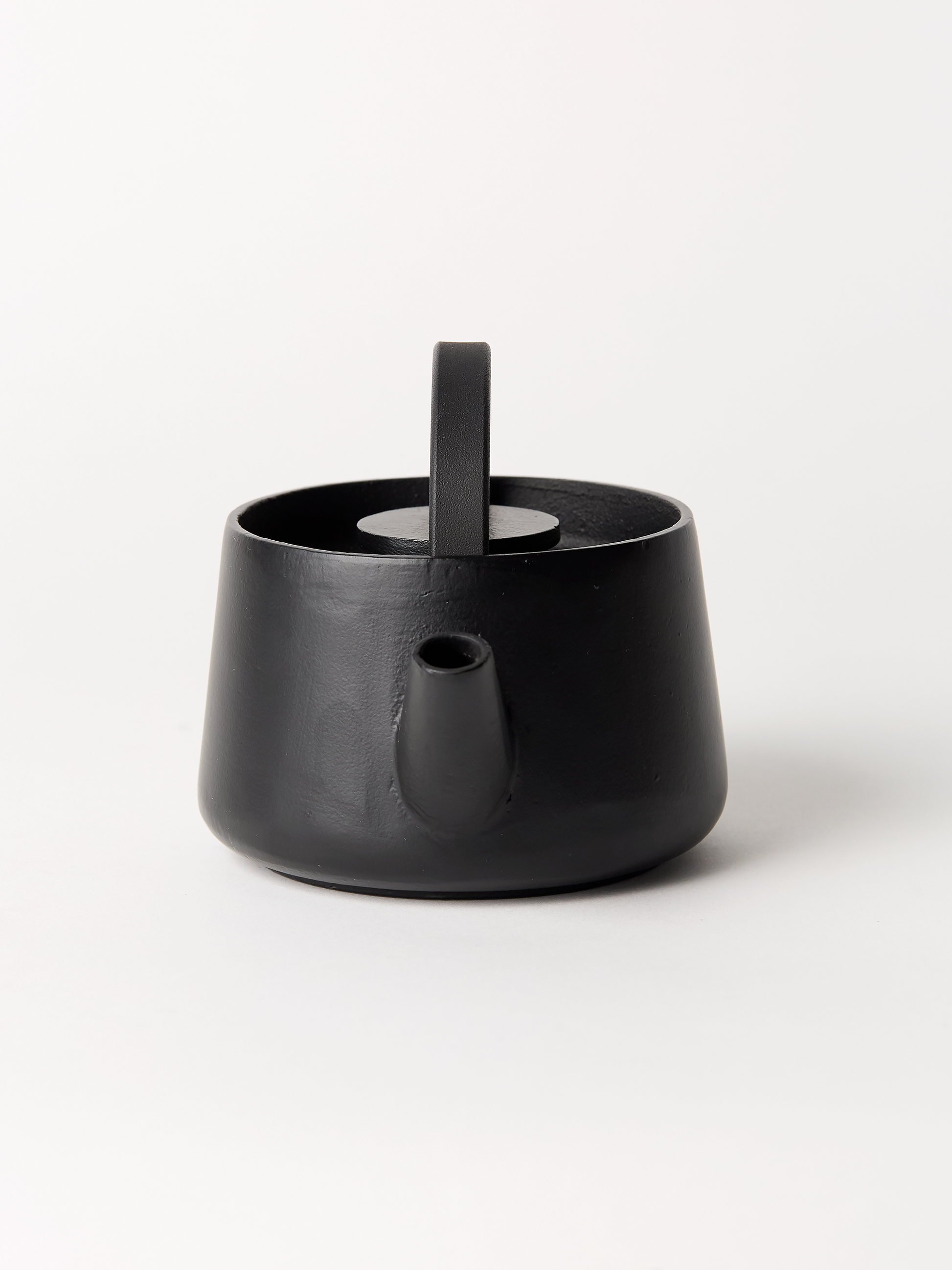 Black ceramic teapot on a white background