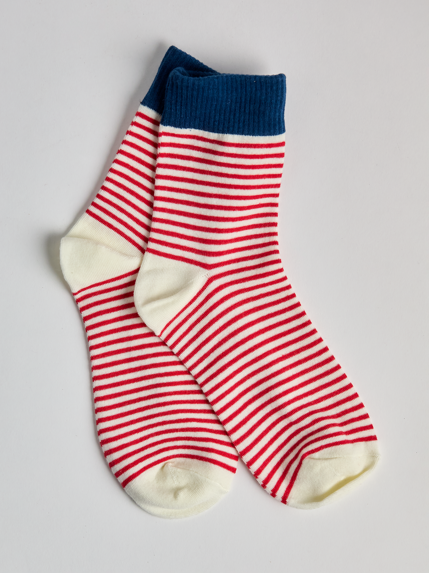 Striped socks with blue top and red and white stripes on a light gray background full image 2.